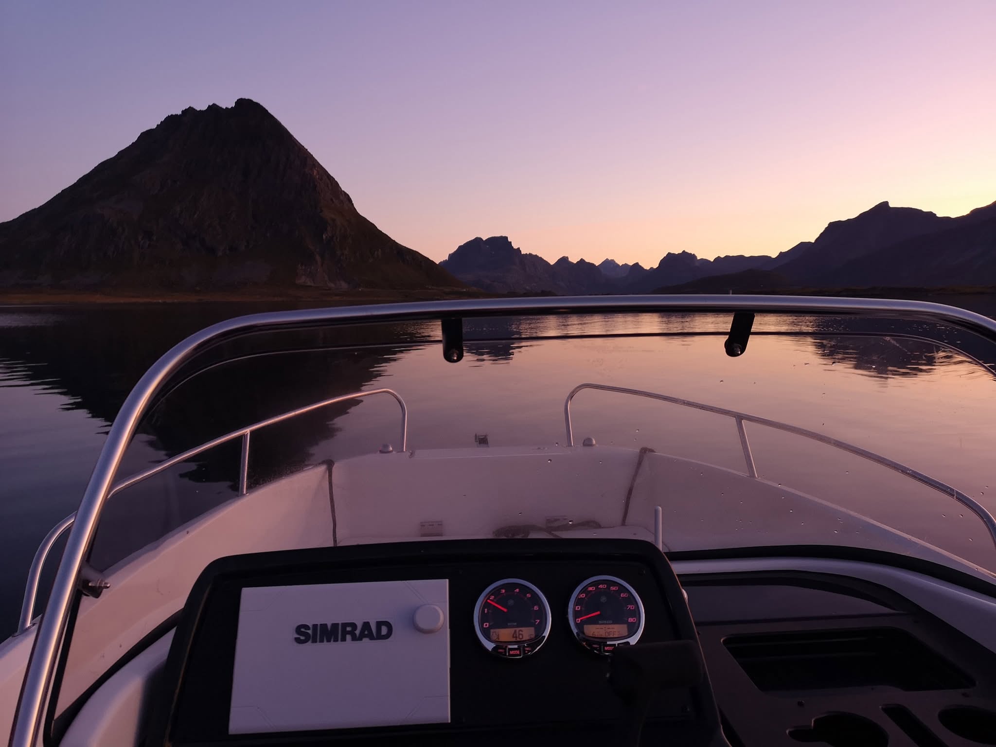 Båt på stille sjø i Lofoten i solnedgang